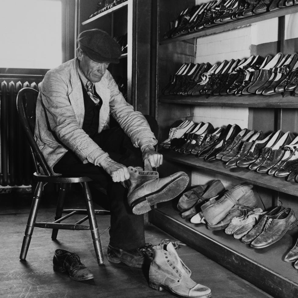 Um homem a experimentar sapatos em segunda mão nos anos 50.