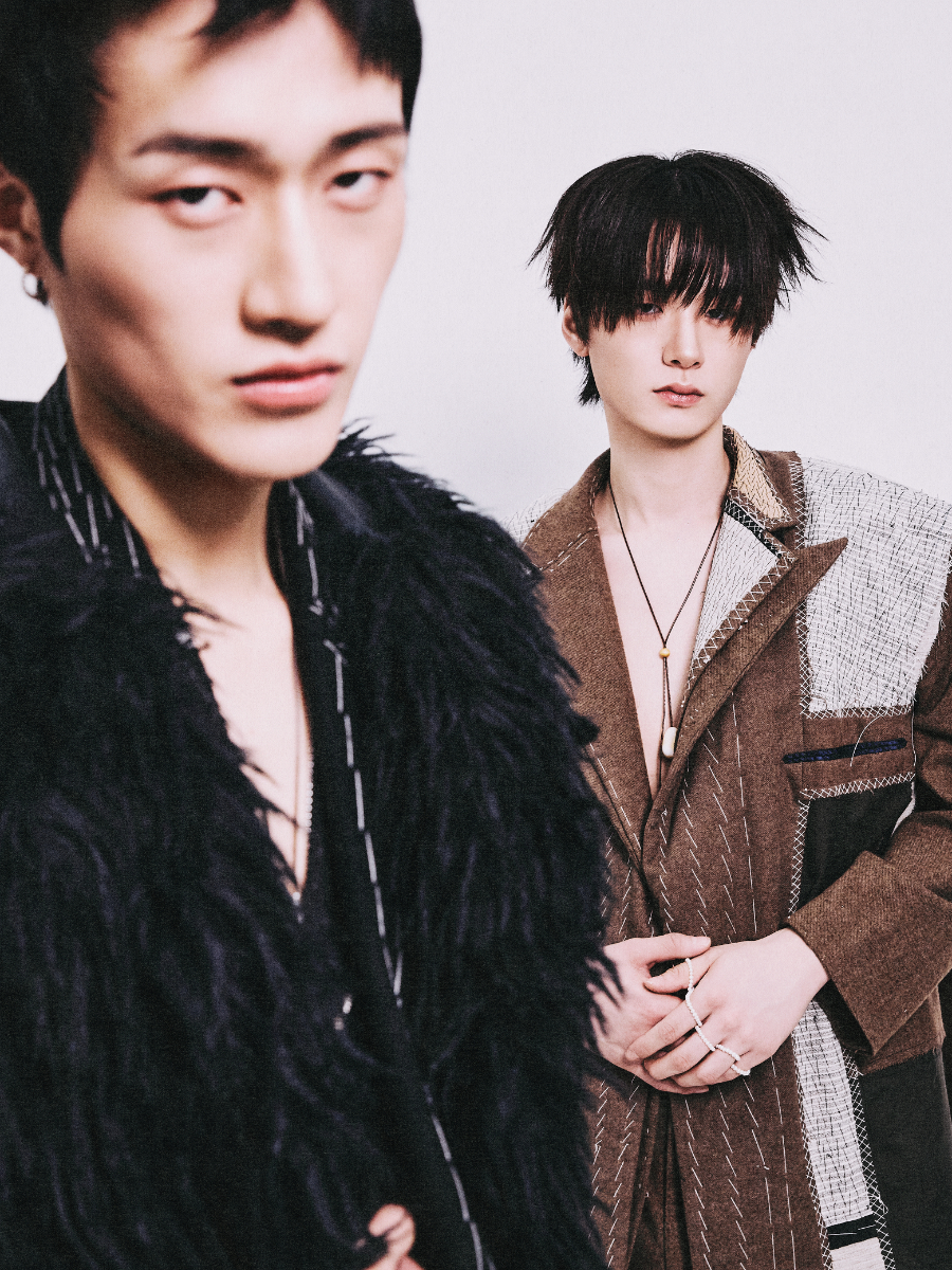 Da esquerda para a direita: Nam Hyun Kim: sobretudo, HANNAH SHIN. Casaco (por dentro) e calças, TAEK MIN KANG. Botas, SAINT LAURENT BY ANTHONY VACCARELLO. Fio, SSY. Jun Woo Park: casaco e calças: TAEK MIN KANG. Botas, OUR LEGACY. Fios e anéis, da produção.  